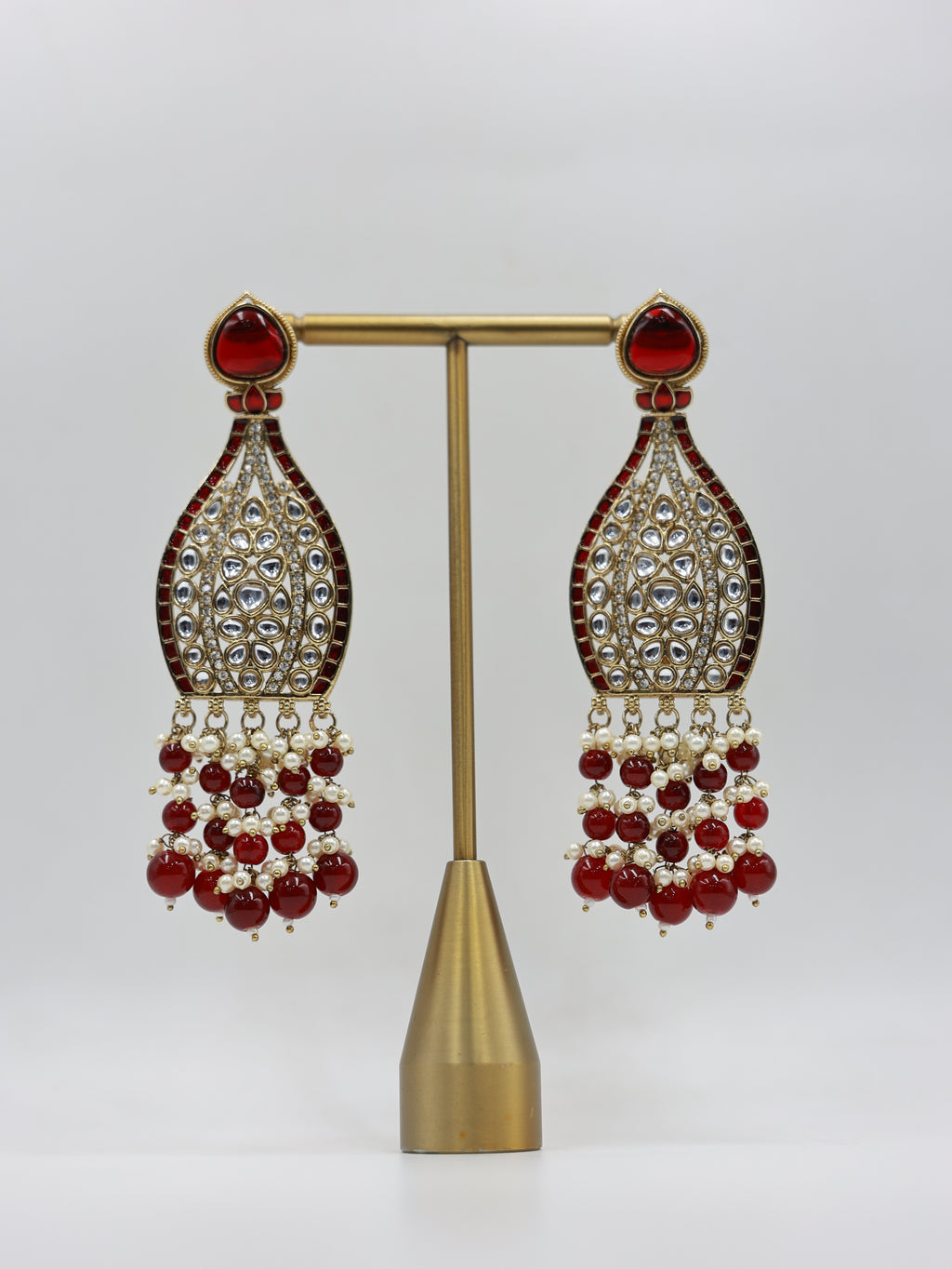Product displayed on stand: ruby and pearl bridal earrings