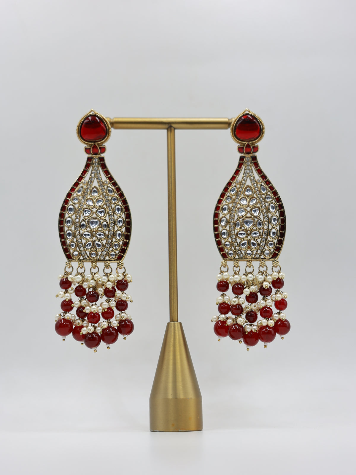 Product displayed on stand: ruby and pearl bridal earrings